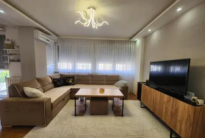 a living room with a couch and a television at Apartman Iris in Tuzla