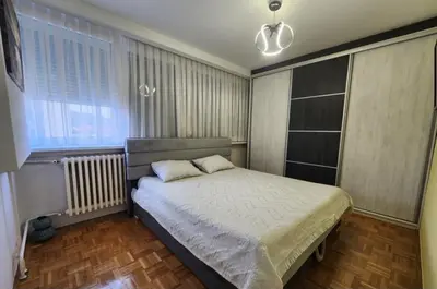 a bedroom with a bed and a window at Apartman Iris in Tuzla