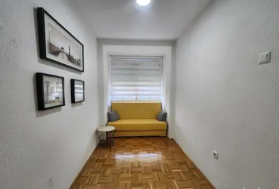 a hallway with a yellow couch in a room at Apartman Iris in Tuzla