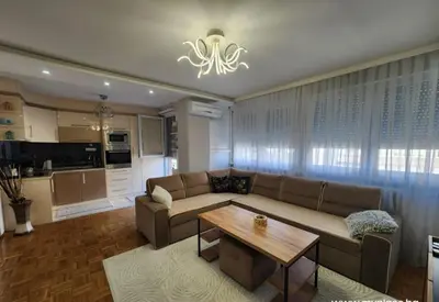 a living room with a couch and a table at Apartman Iris in Tuzla
