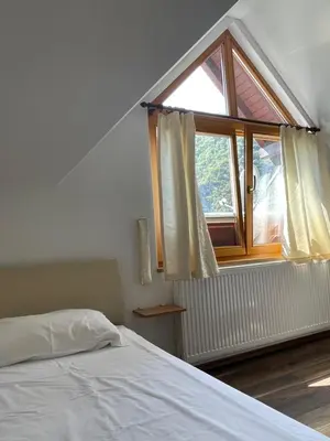a bedroom with a bed and a large window at Restoran Motel Kanjon in Skender Vakuf