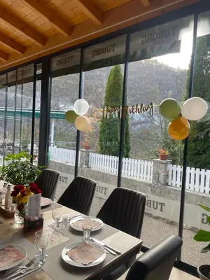 a dining room with a table and chairs and a window at Restoran Motel Kanjon in Skender Vakuf