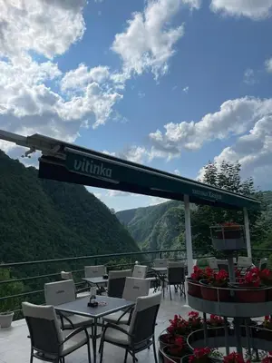 a restaurant with tables and chairs on a balcony at Restoran Motel Kanjon in Skender Vakuf