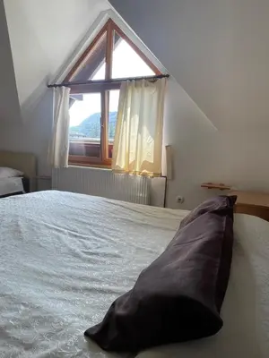 a bedroom with a large bed with a window at Restoran Motel Kanjon in Skender Vakuf