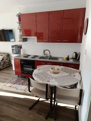 a small kitchen with a table and a sink at Apartman Una na dlanu, Novi Grad in Bosanski Novi