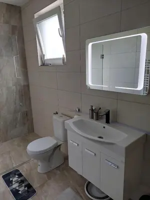 a bathroom with a toilet and a sink and a mirror at Apartman Una na dlanu, Novi Grad in Bosanski Novi