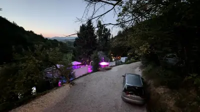 a car parked on a gravel road in front of a house at Vila N&M in Grad