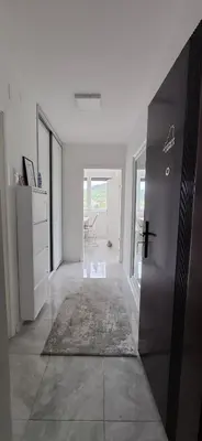 a hallway with a door and a room with a rug at Apartman Lamela in Zenica