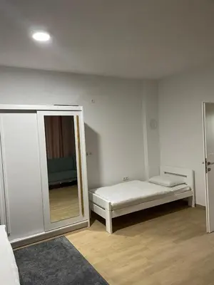 a white room with a bed and a mirror at Villa Bella Una-Apartman in Ostrožac