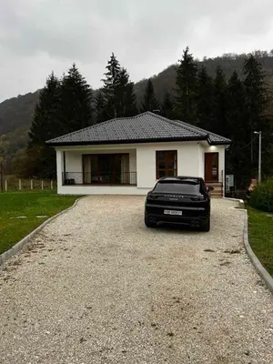 a black car parked in front of a house at Villa Bella Una-Apartman in Ostrožac
