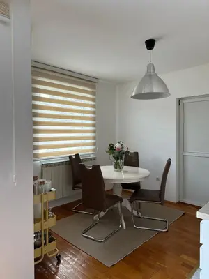 a dining room with a white table and chairs at Apartman Siesta in Kiseljak