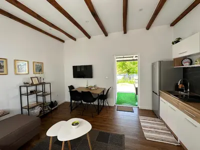 a living room with a couch and a table at Small House Apartment in Bihać