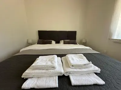 a bedroom with a bed with white towels on it at Small House Apartment in Bihać