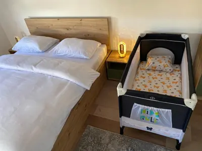 two twin beds in a room with a crib at Luxury Pyramid Apartment II Visoko in Visoko