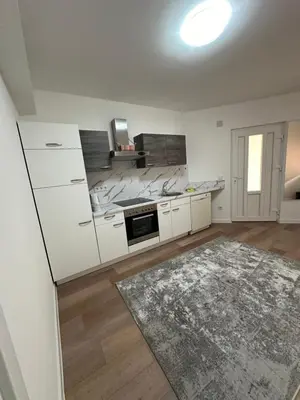 a kitchen with white cabinets and a rug at Luxury Pyramid Apartment II Visoko in Visoko