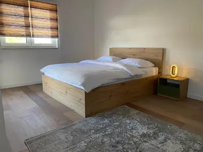 a bedroom with a wooden bed with white sheets and pillows at Luxury Pyramid Apartment II Visoko in Visoko