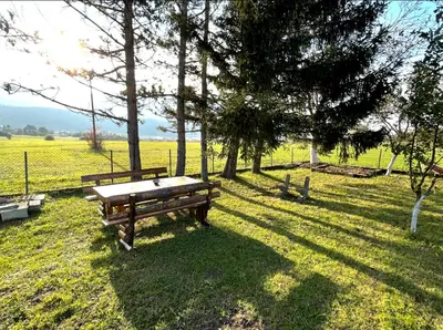 a park with a bench and trees in a field at Peace Holiday Home in Bihać