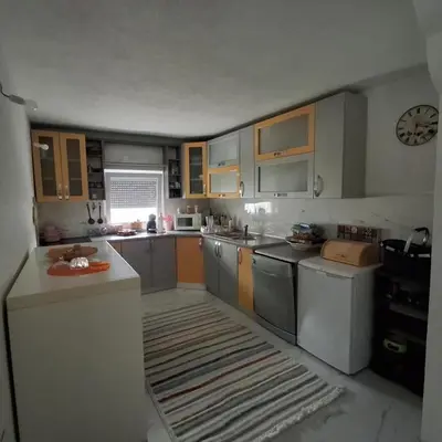 a kitchen with wooden cabinets and stainless steel appliances at Peace Holiday Home in Bihać