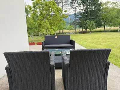 two chairs and a table with a laptop on it at Peace Holiday Home in Bihać