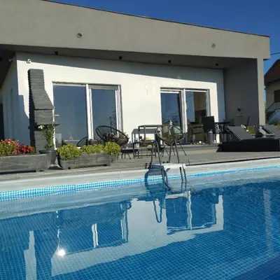 a swimming pool in front of a house at Casa Rado in Banja Luka