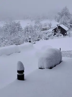 a snow covered yard with two cars covered in snow at Casa Rado in Banja Luka