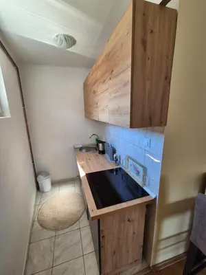 a small kitchen with a sink and wooden cabinets at Una in Bosanski Novi