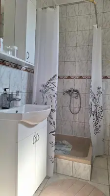 a bathroom with a shower with a sink and a shower curtain at Una in Bosanski Novi