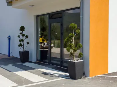 two potted plants are sitting outside of a building at Motel Anić in Novi Travnik