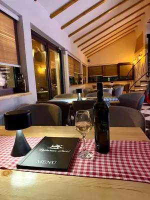 a bottle of wine sitting on a table with a glass at Motel Anić in Novi Travnik