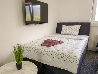 a bedroom with a bed with a mirror and a table at Motel Anić in Novi Travnik