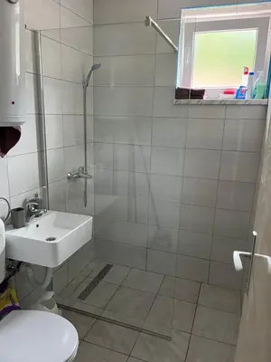 a bathroom with a shower and a sink and a toilet at Apartman KUNA in Drvar