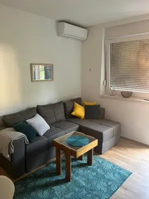 a living room with a couch and a table at Apartman KUNA in Drvar