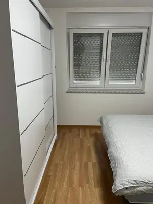 a bedroom with a bed and a window at Apartman KUNA in Drvar