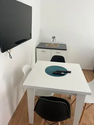a white table with two chairs and a television at Apartman KUNA in Drvar