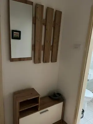 a bathroom with a clock and a mirror on the wall at Apartman KUNA in Drvar