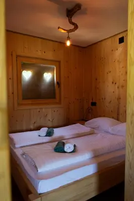 a bedroom with a large bed with towels on it at Riverside Cabin Pisak in Kulen Vakuf