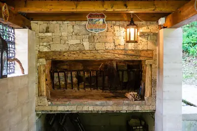 a fireplace in a stone wall with a lamp at Riverside Cabin Pisak in Kulen Vakuf