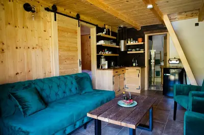 a living room with a blue couch and a table at Riverside Cabin Pisak in Kulen Vakuf