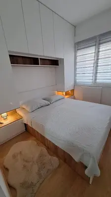 a bedroom with a large bed with white cabinets at Stan Banjaluka Ada 1 in Rebrovac