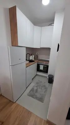 a kitchen with white cabinets and a refrigerator at Stan Banjaluka Ada 1 in Rebrovac