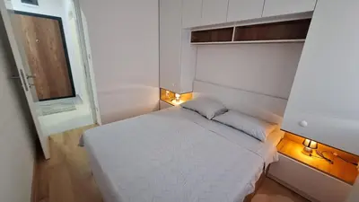 a small bedroom with a white bed and a window at Stan Banjaluka Ada 1 in Rebrovac