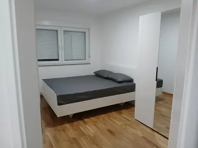 a small bedroom with a bed and a window at KEJ LUX Apartman in Bosanska Gradiška