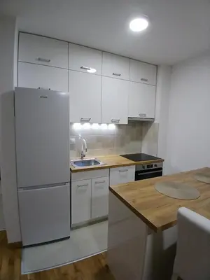 a kitchen with a white refrigerator and a sink at KEJ LUX Apartman in Bosanska Gradiška