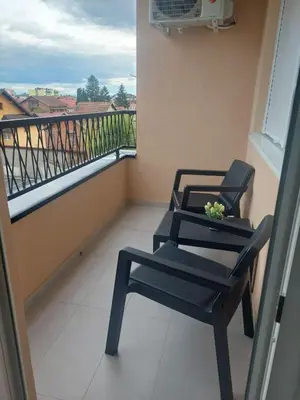 a balcony with two chairs and a table and a window at KEJ LUX Apartman in Bosanska Gradiška