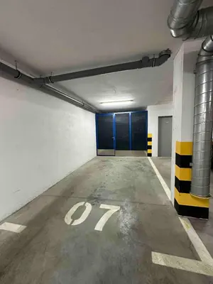 an empty garage with blue doors and a parking lot at Apartman 23 Lux in Banja Luka