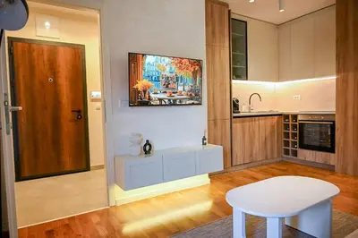 a kitchen with a white table and a white stool at Apartmani Galerija in Banja Luka