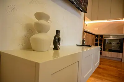 a white counter with a vase and a bottle on it at Apartmani Galerija in Banja Luka