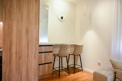 a small kitchen with two stools and a mirror at Apartmani Galerija in Banja Luka