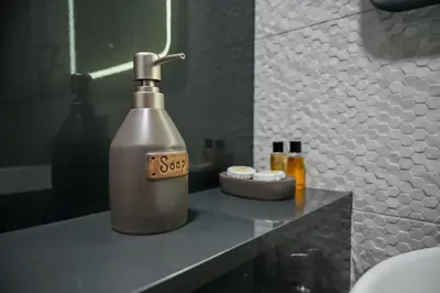 a bottle of soap sitting on a counter in a bathroom at Apartmani Galerija in Banja Luka