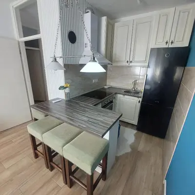 a kitchen with white cabinets and a black refrigerator at Stan na dan centar Jevrejska Banja Luka in Banja Luka